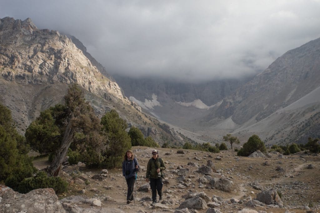 Two trekkers hiking in a rocky mountain valley
